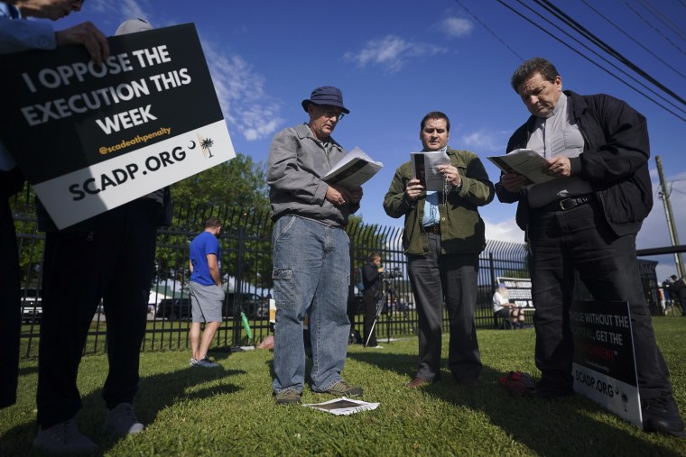 Personas rezan afuera de la prisión antes de la ejecución por fusilamiento de Mikal Mahdi.