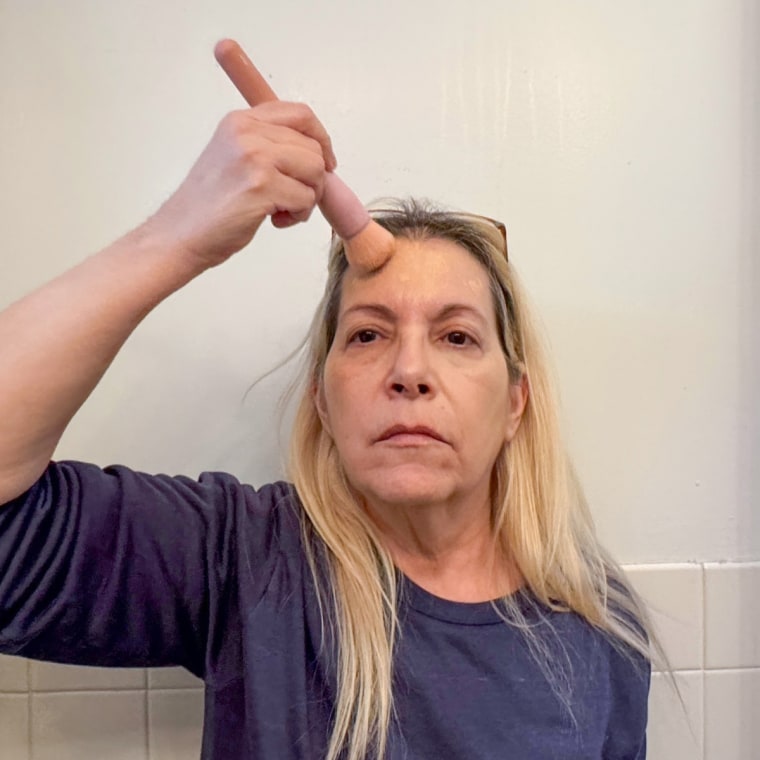 Applying the L’Oreal Paris Lumi Le Glow Tint with a makeup brush.