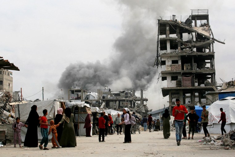 Palestinians run for cover as an Israeli strike hits the home