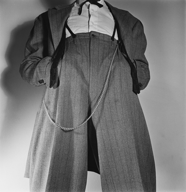 Low angle view of a man wearing a Zoot suit with a watch chain hanging from the waist, his hands in his pockets circa 1945.