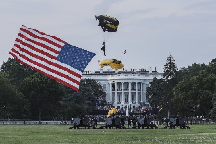 A equipe de pára -quedas do Exército de Ouro do Exército dos EUA carrega uma bandeira americana, aterrissando na Casa Branca Ellipse em julho de 2020.