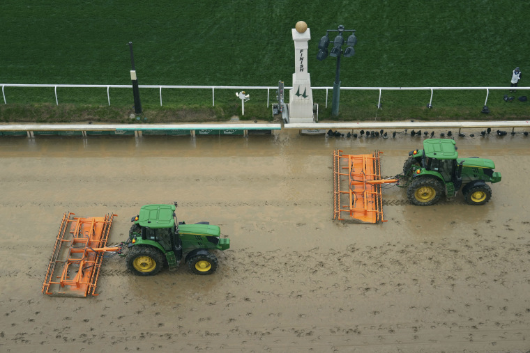 Tractors prepare the muddy track at Churchill Downs