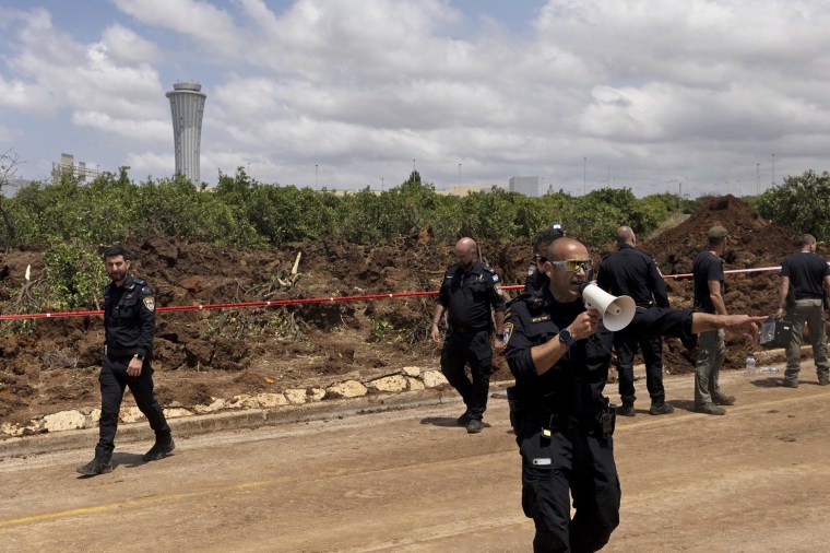 Police inspect the scene after a ballistic missile fired from Yemen by the Houthis struck a field near Israel's Ben Gurion Airport on May 4, 2025.
