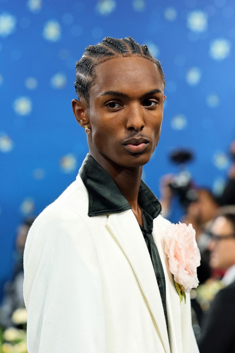 Christian Latchman sports a pink rose on the Met Gala carpet.