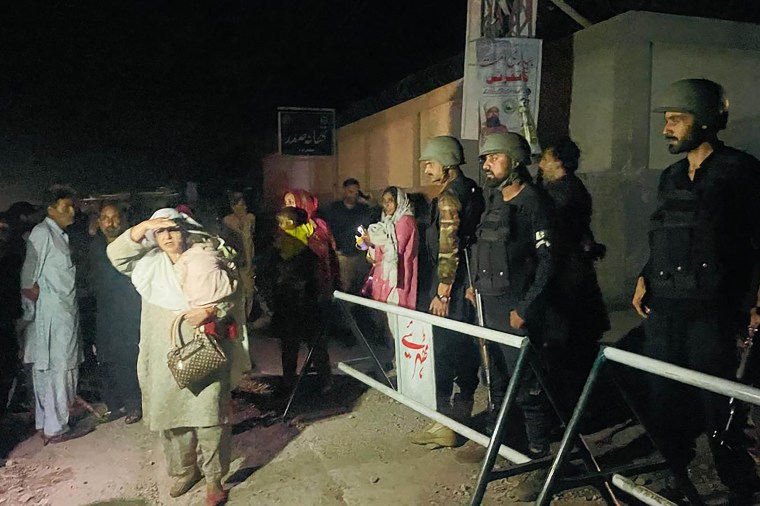 Security personnel cordon-off a street as local residents evacuate their homes near the site of a strike in Muzaffarabad