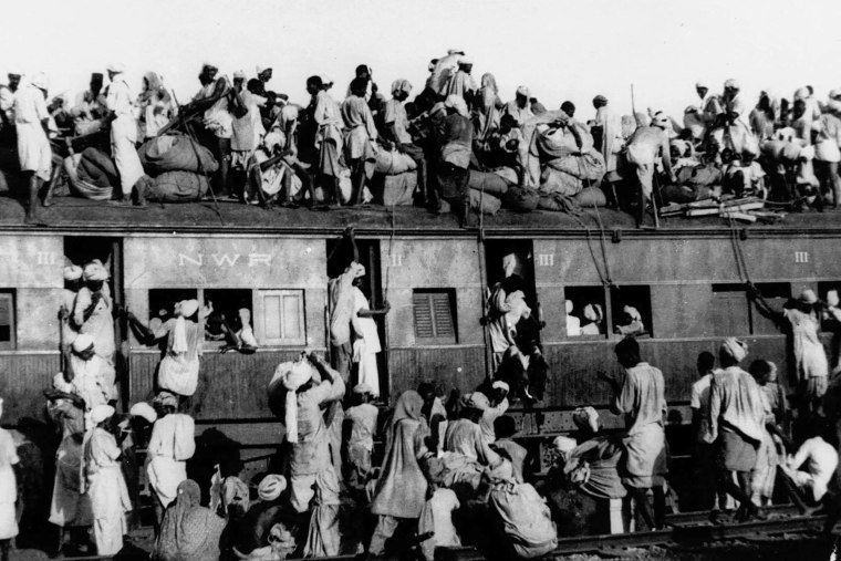Hundreds of Muslim refugees crowd on top a train leaving New Delhi for Pakistan.