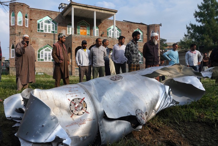 People look at a part of an aircraft in Wuyan village in the Himalaya region of Kashmir
