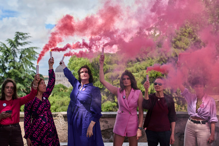 Activists from the Women's Ordination Conference release pink smoke