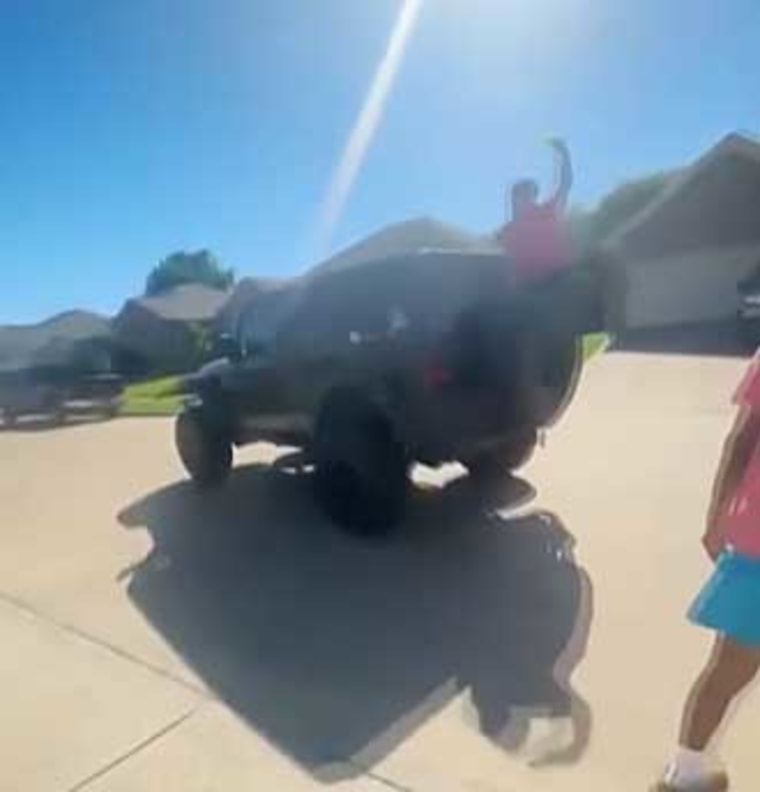 Isaac Leal rides on the back of a Jeep as he plays "Senior Assassin."