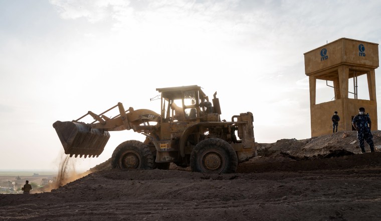 A excavator moves the earth at the excavation site.
