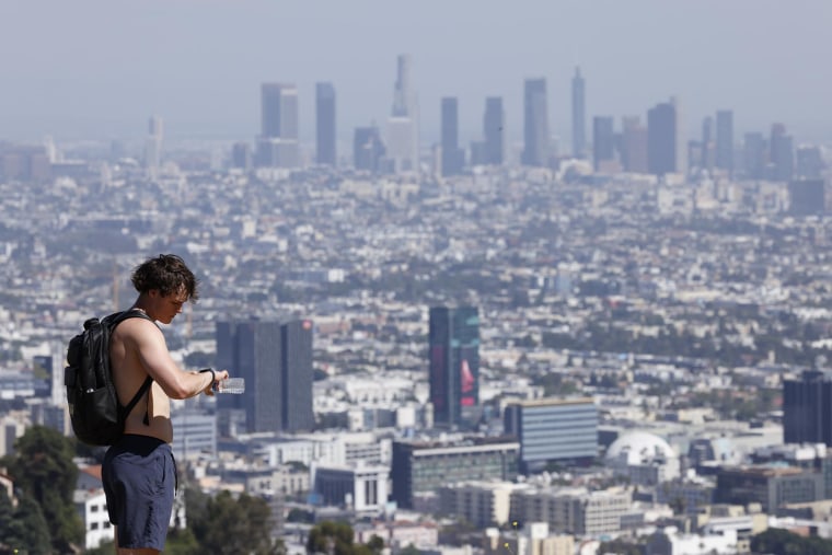 A man stops to hydrate and check his watch during a heat wave in Los Angeles on Sunday, May 11, 2025.
