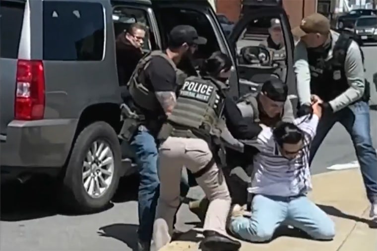 Agents detain a man in Chelsea, Mass. on Sunday.