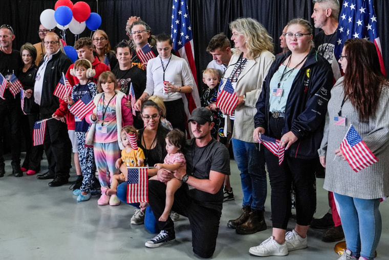 A group of people pose with American flags