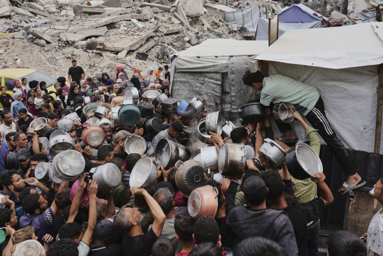 Palestinians struggle to get donated food at a community kitchen
