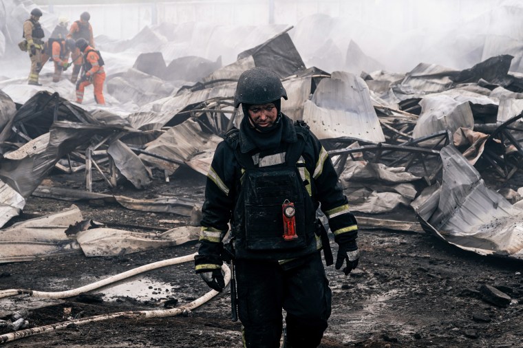 Firefighters extinguish a fire at a plastic tableware business damaged by Russian drone attack 