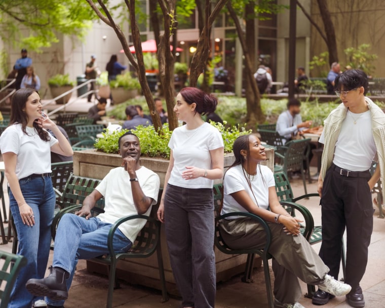 A group of NBC Select editors wearing a variety of white t-shirts in a public park.