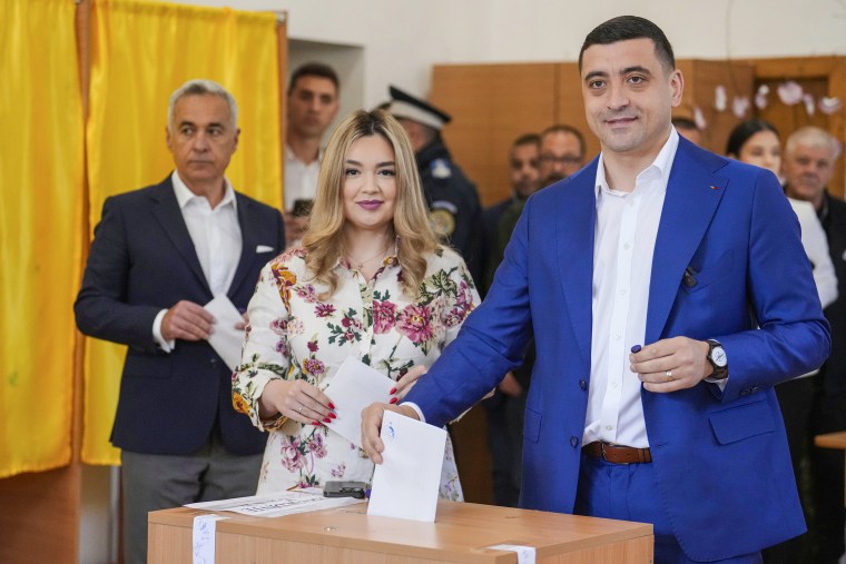 Presidential candidate George Simion casts his vote next to his wife Ilinca.