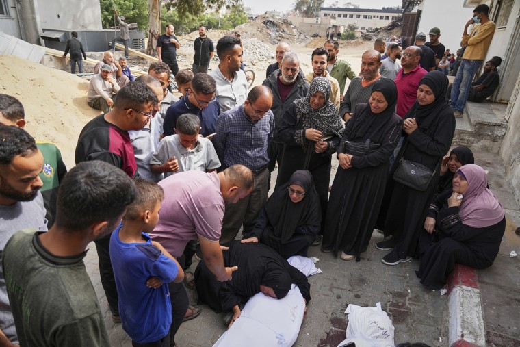 Relatives mourn over the bodies of several members who were killed earlier when an Israeli army strike hit their home.