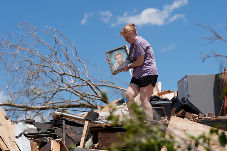 Hailee Allen holds a family picture saved from Lynn and Don White's home in London, Ky.