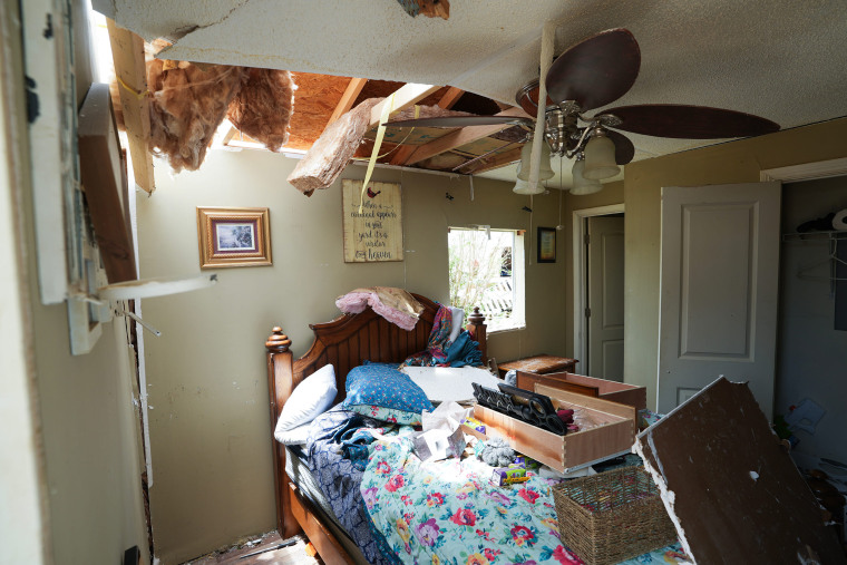 Residents salvage belongings and assess damage after a tornado in London, Ky.