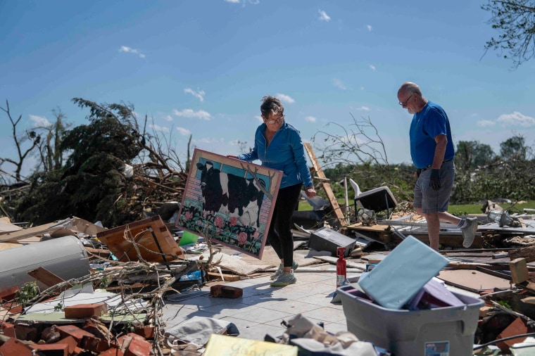 A couple search for belongings following a tornado in London, Ky.