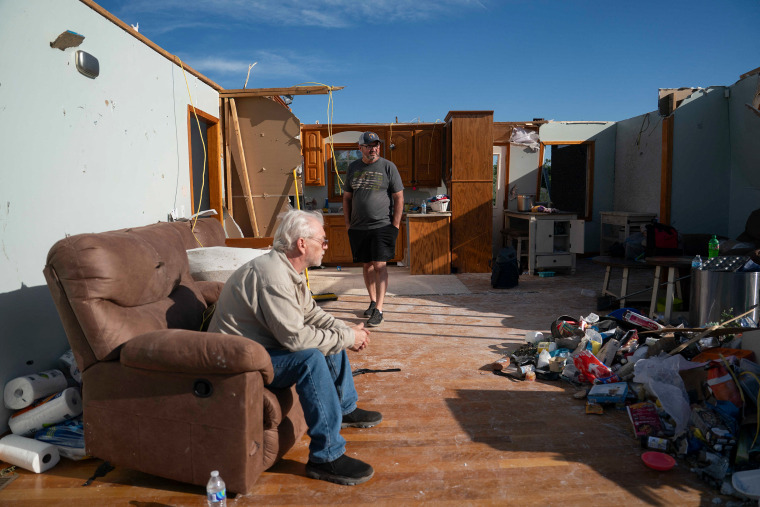 Nathan Anders, right, in the remnants of his home with a relative, Raymond Samples, after a tornado hit in London, Ky.