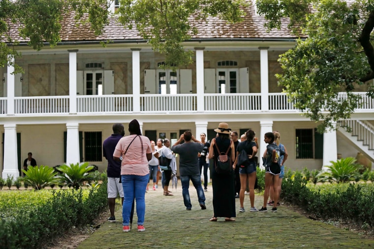 Visitors stand outside the main plantation house