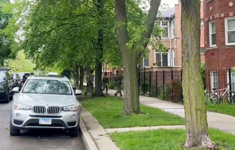 Armed FBI officers arrive at an address in Chicago this morning.