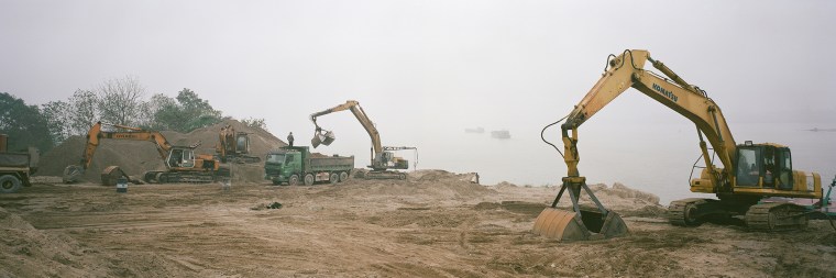 Barges deliver sand for use in Hanoi's concrete yards along the Red River