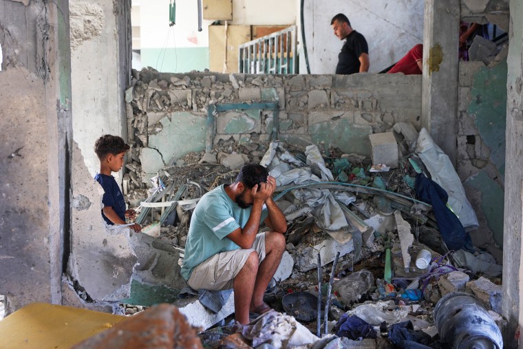 A man sat amongst rubble