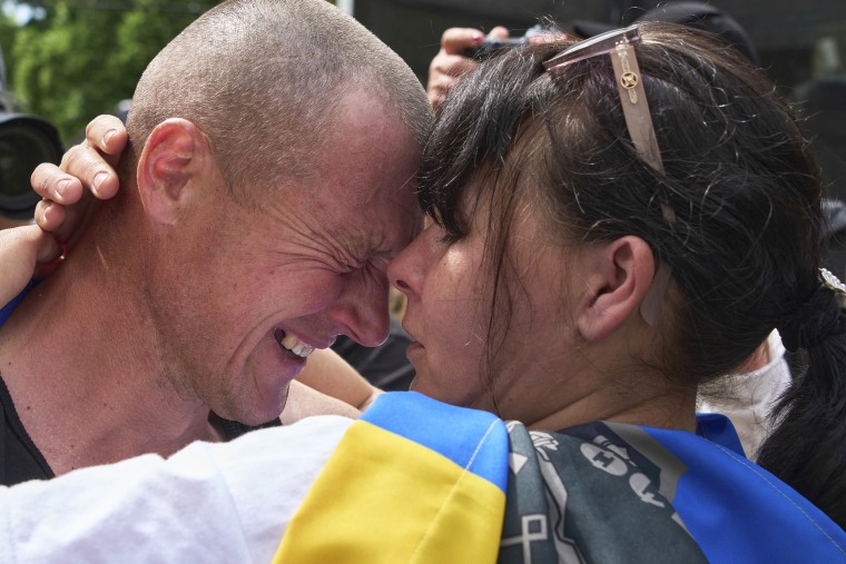 A Ukrainian serviceman Vitaly, hugs his woman Olena, aft returning from captivity