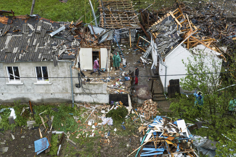 An aerial shot of people clearing the rubble of residential houses