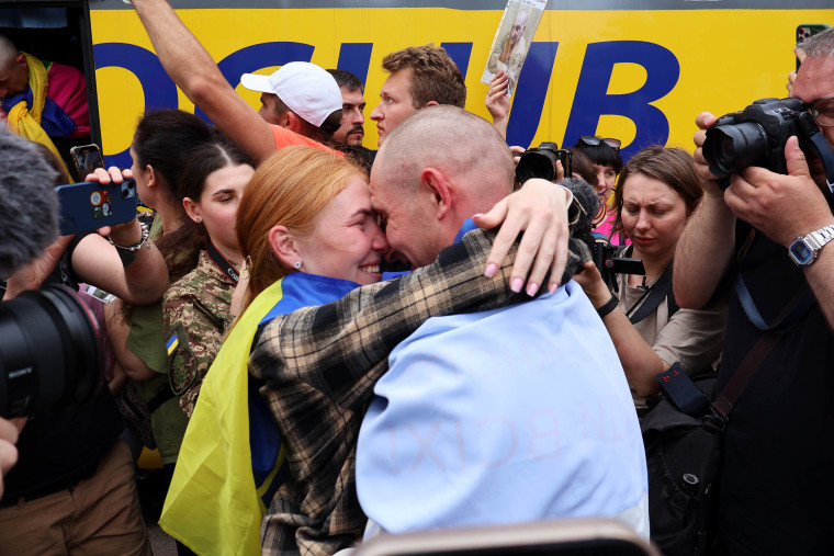 A Ukrainian soldier, released from Russian captivity, hugging a woman