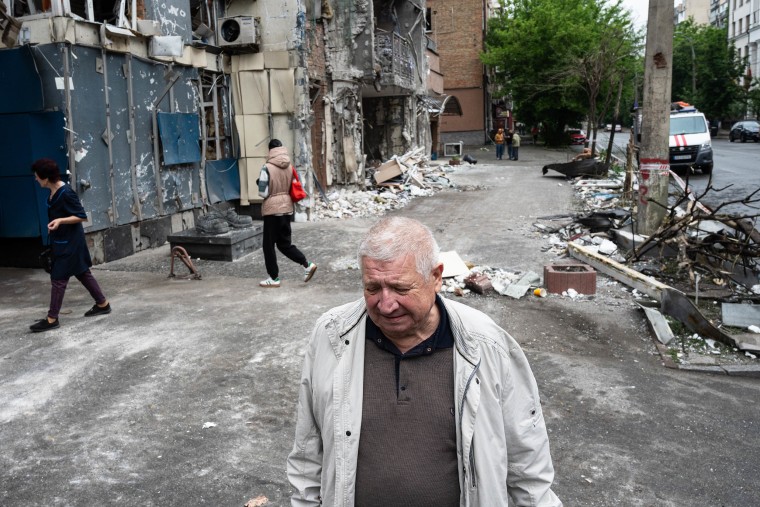 A distressed man in front of a building damaged as the result of a Russian attack