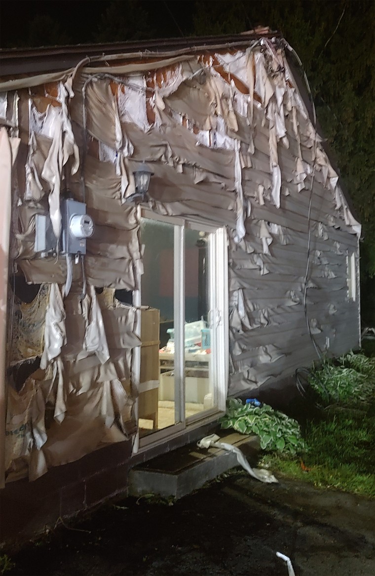 Melted siding is shown after a fire.