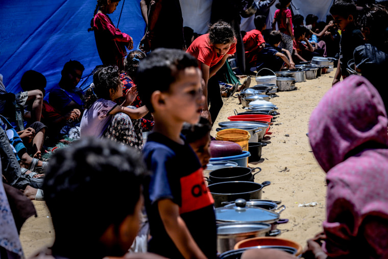 Displaced Palestinians queue for hot meals amid worsening crisis in Gaza.