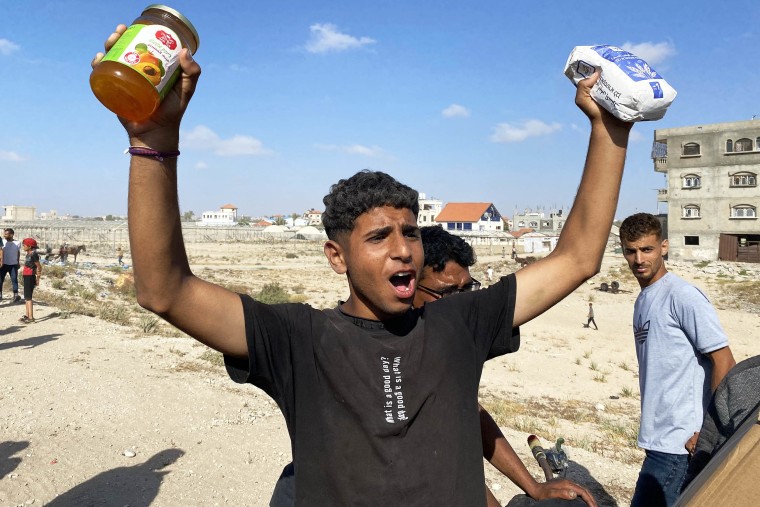 A man holding food from an aid package