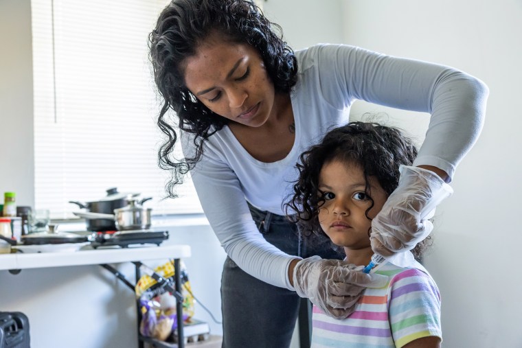 As part of her daily routine, Deysi Vargas runs a saline solution through her daughter's intravenous line before her morning shower and school.