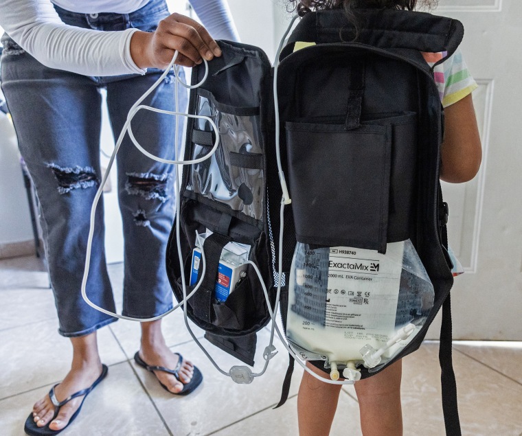 Deysi Vargas' four-year-old daughter wears the backpack that delivers nutritents intravenously.