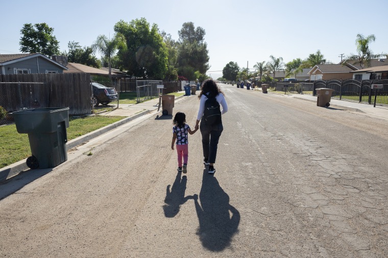 Deysi Vargas and her daughter S.G.V. walk about 15 minutes to the child's school. The mother carries the daughter most of the way since she can't walk for very long.