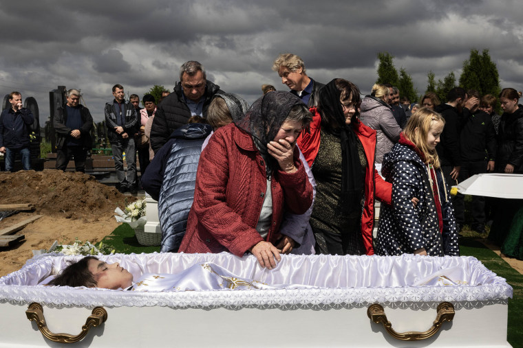 A grandmother at her grandson's casket.