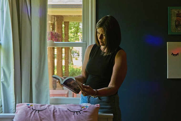 Candace looks at a book in her daughter's bedroom.