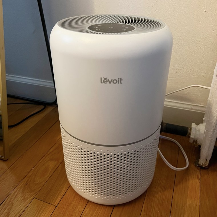 A photo of the Levoit Core 300 air purifier plugged into the corner of a room.