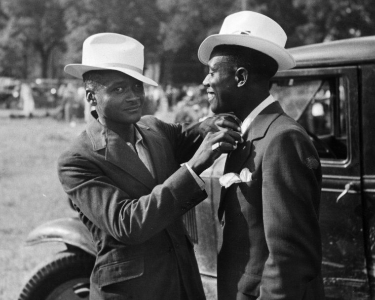 An African-American man adjusting his friend's tie in Kansas City, circa 1940