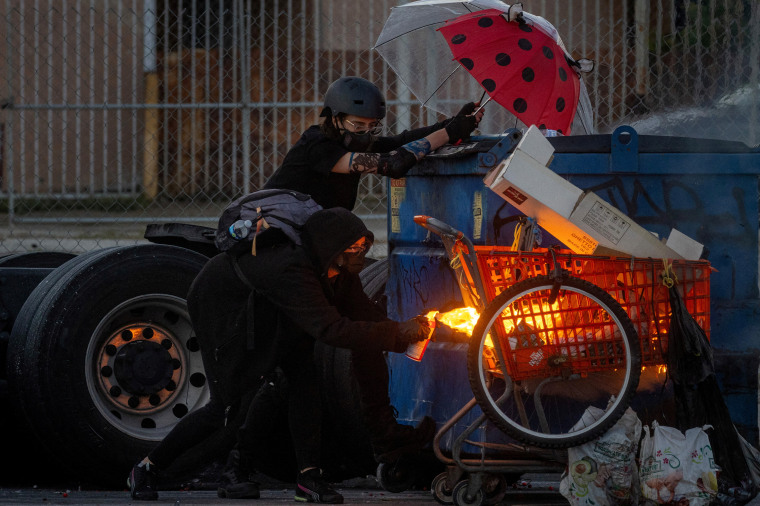 A protester sets fire to a shopping cart during a standoff with law enforcement in Compton