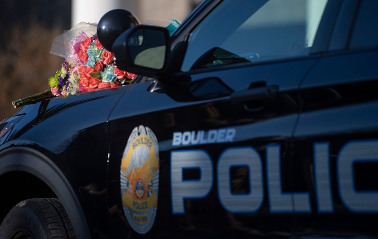 Flowers on the hood of a patrol car during a news conference at the Boulder Police Department.