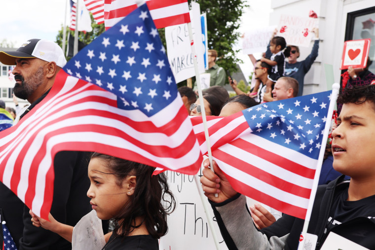 Protesters hold American flags.