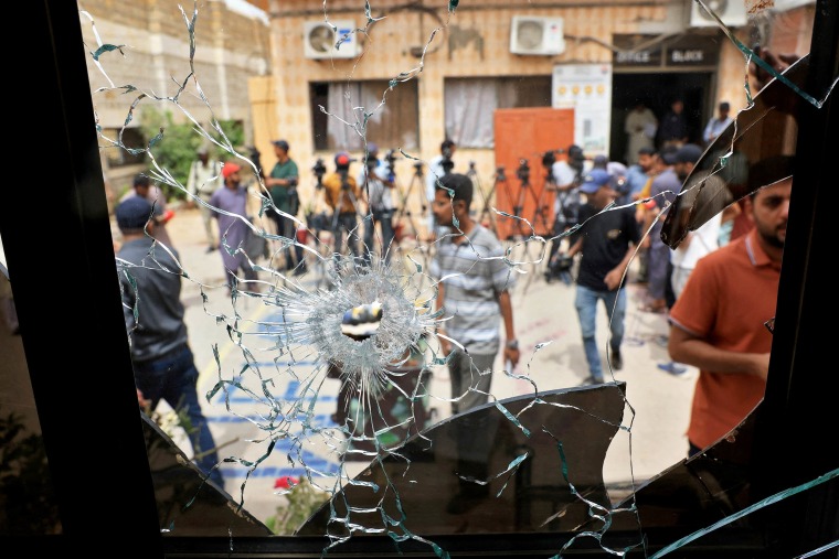 Members of media are seen through a broken glass window inside the premises of the district Malir jail after dozens of prisoners escaped from the jail on the outskirts of Karachi