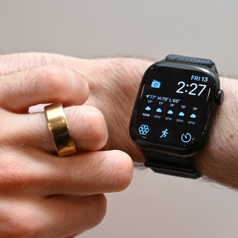 A close-up of the writer’s left hand and right wrist. One has a gold Oura Ring on it, the other is wearing an Apple Watch Series 10.