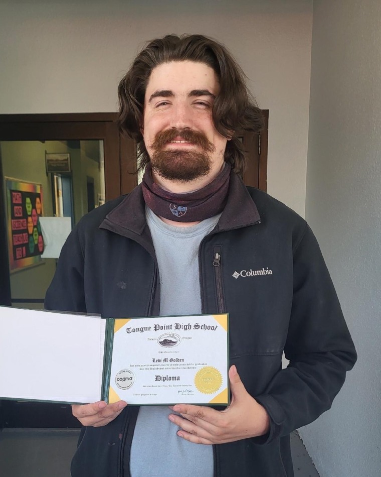 Levi Golden holding his diploma.